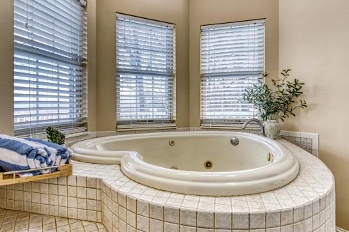 a large bath tub in a bathroom with windows at Ober Hideaway, Hot Tub, WIFI, 560 FREE tickets each paid day!!! in Gatlinburg