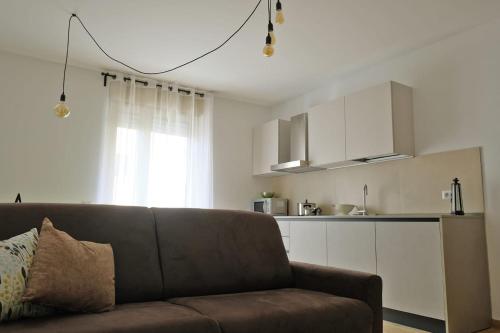a living room with a couch and a kitchen at I Castelli - Alle 5 Torri in Mezzolombardo