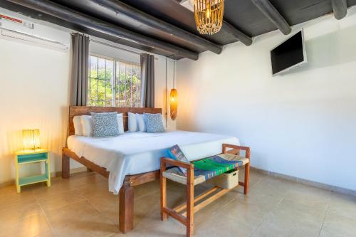 a bedroom with a large bed and a window at Vito Hotel Boutique Taganga in Taganga