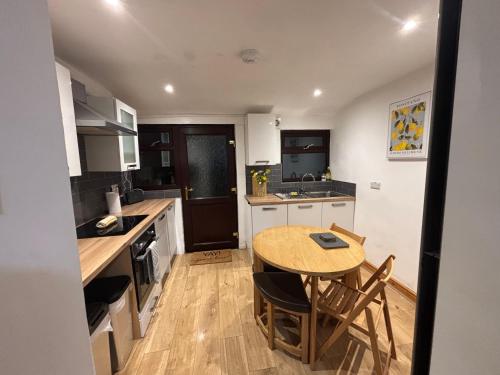 a kitchen with a wooden table and a wooden floor at Cheerful 3 Bedroom Townhouse in Bangor