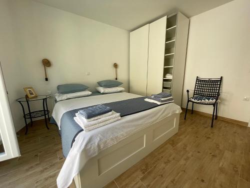a bedroom with two beds and a chair at House Damić in Korčula