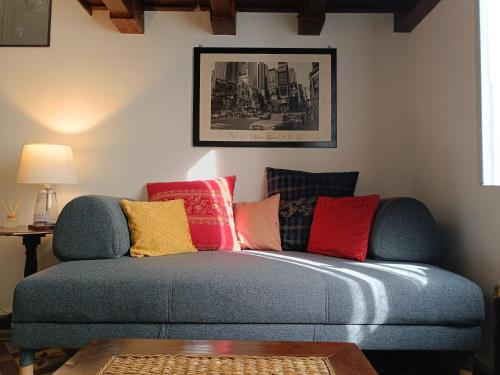 a living room with a blue couch with colorful pillows at lovely vintage apartment climatizzato inalpi in Turin