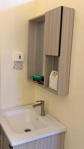 a bathroom with a sink and a mirror at Noorhaven stay in Watamu