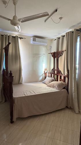 a bedroom with a large bed with a wooden frame at Noorhaven stay in Watamu
