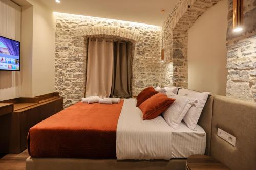a bedroom with a large bed and a tv at NOMA Boutique Hotel in Shkodër