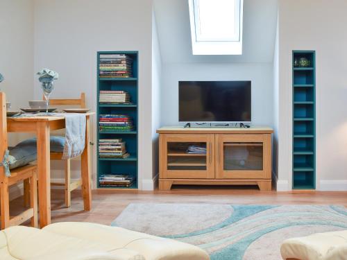 a living room with a tv and a table and a table sidx sidx at Leveret Lodge in Burgh