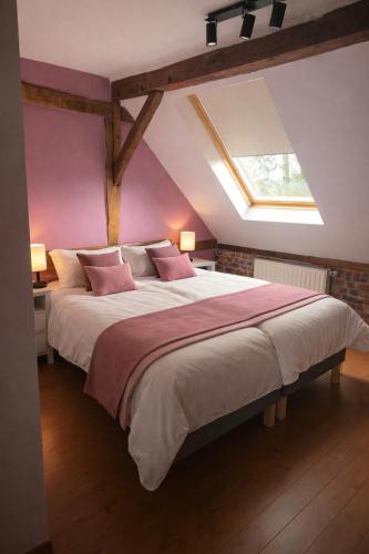 a bedroom with a large bed with a skylight at Le refuge de Séve - Loft de Yves in Momignies