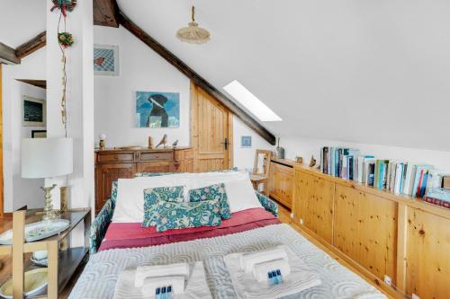 a bedroom with a bed and a book shelf with books at La Grangia - mountain loft in Rollieres