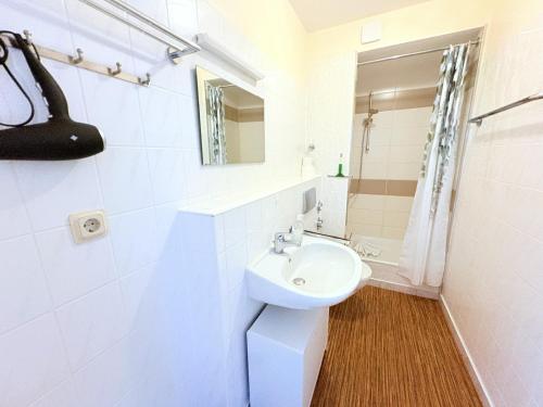 a white bathroom with a sink and a mirror at Boddenhof Apartment 48 - Terrasse für Hundefreunde in Buschvitz