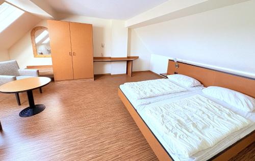 a small bedroom with a bed and a table at Boddenhof Apartment 52 - Balkon, hundefreundlich in Buschvitz