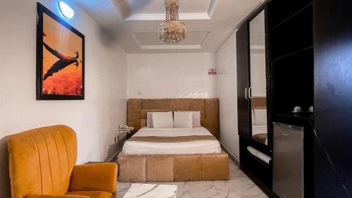 a bedroom with a bed and a chair and a chandelier at Luxury Hotel Deluxe Room - Sleeps 2 - Gym - Pool in Lekki
