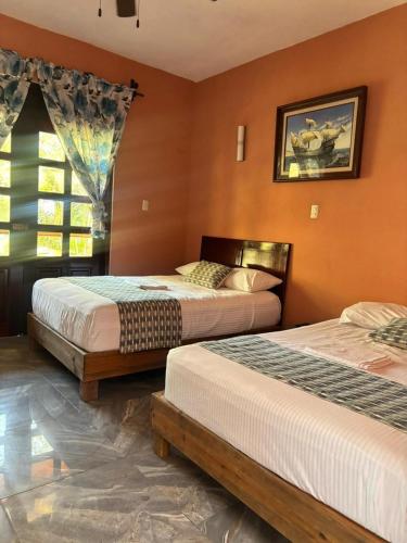 a bedroom with two beds and a window at Hotel Rosa de los vientos in Tuxpan de Rodríguez Cano