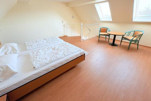 a bedroom with a bed and a table and chairs at Boddenhof Apartment 54 - Balkon, Parkplatz, ruhig in Stedar