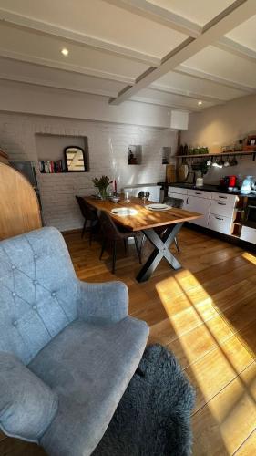 a living room with a table and a couch and a kitchen at Vakantiehuis Rosa in Ons Belang