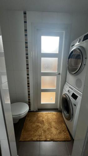 a bathroom with a washing machine and a washer at Vakantiehuis Rosa in Ons Belang