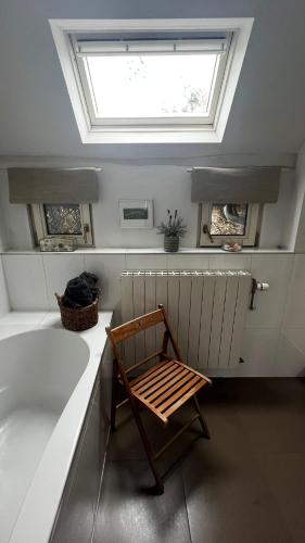 a wooden chair sitting in a bathroom with a skylight at Vakantiehuis Rosa in Ons Belang