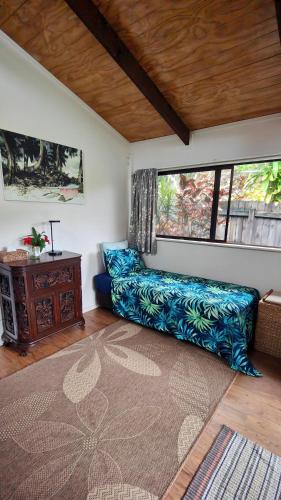 a living room with a blue couch and a window at Muri Lagoon Cottage in Rarotonga
