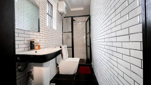 a black and white bathroom with a sink and a toilet at Executive Luxury Room - Spa - Gym - Parking in Lekki