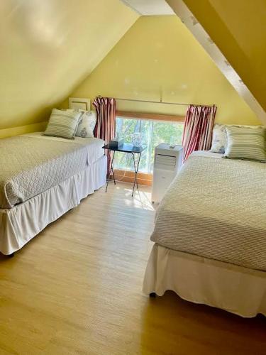 two beds sitting in a room with a window at Hilltop Landing in Digby