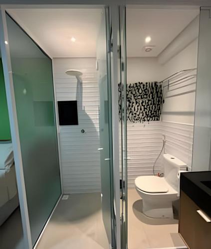 a bathroom with a toilet and a glass shower door at Flat a 20 metros da praia in João Pessoa