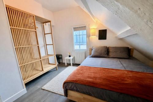 a bedroom with a large bed in a attic at Le Duplex 4p - 2 chambres, centre Compiègne in Compiègne
