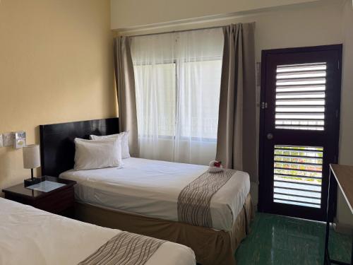 a hotel room with two beds and a window at Nuevo Paris Hotel in Mérida