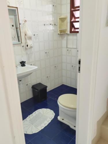 a bathroom with a toilet and a sink at Quarto Grande na Praia do Guaiúba! in Guarujá