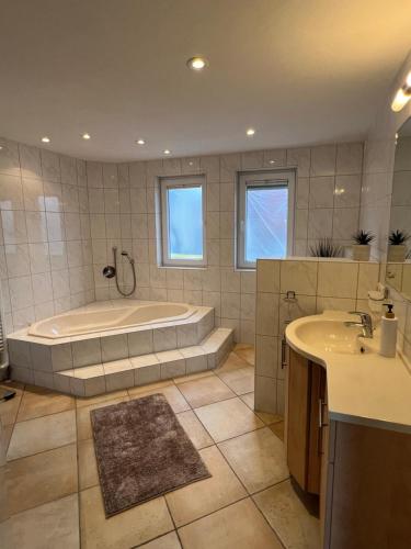 a large bathroom with a tub and a sink at Groasmückle Apartment in Tauberbischofsheim