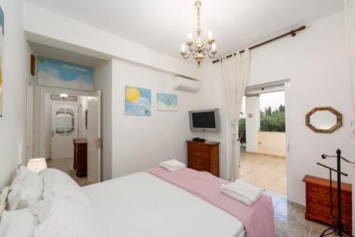 a bedroom with a large bed and a television at Azure Garden Retreat in Aigio