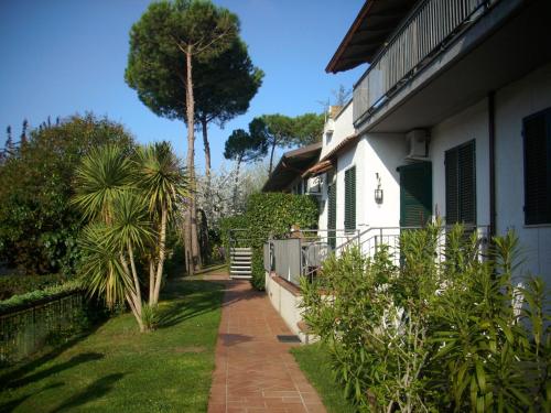 a walkway next to a house with a palm tree at Residence Al Lago in Castiglione del Lago