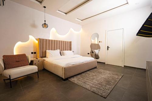 a bedroom with a bed and a chair at Ocean View Lekki Ikate in Alaguntan