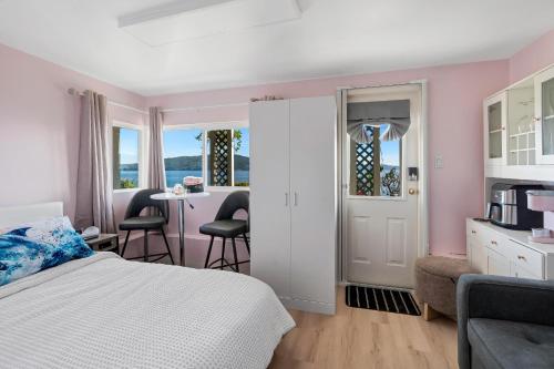 a bedroom with a bed and a table and chairs at Beachbreeze Oceanfront 4BR1Den4BA Romantic Sunrise & Celestial Views in Mill Bay