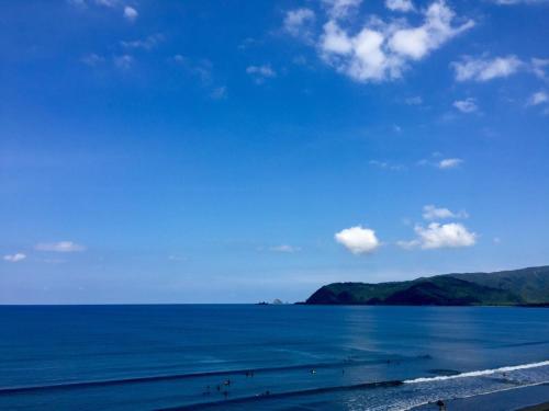 a view of a beach with people on the water at Playa Azul Baler in Baler