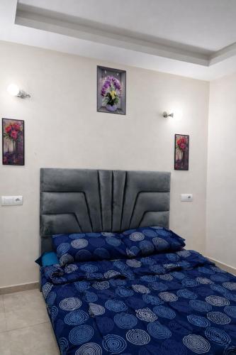 a bedroom with a blue bed with a black headboard at Diamonds in Rabat