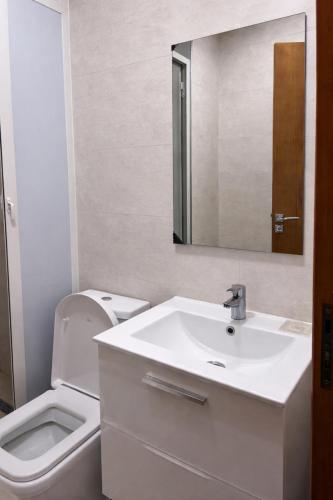 a bathroom with a sink and a toilet and a mirror at Diamonds in Rabat