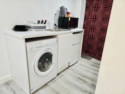 a kitchen with a washing machine and a sink at Enjoy the comfort at private room en-suite with free Parking - near Luton airport in Luton