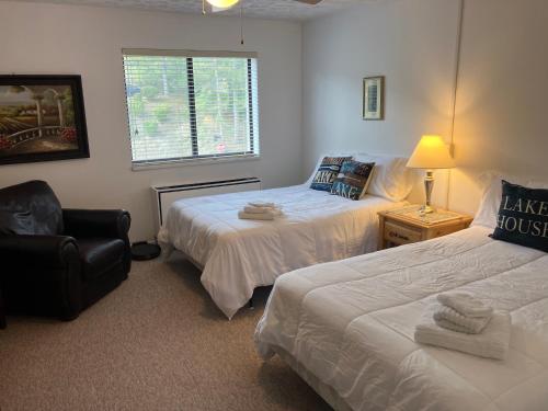 a bedroom with two beds and a chair and a window at Lakeside Condo with plenty of amenities close to Bristol Mountain - permit - 2024-0018 in Canandaigua
