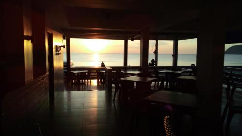 a restaurant with tables and chairs and a view of the ocean at Playa Azul Baler in Baler
