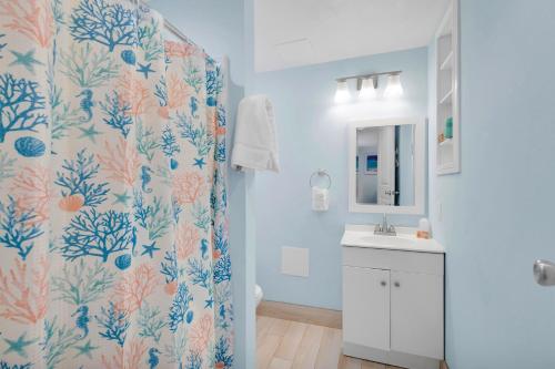 a bathroom with a shower curtain and a sink at Sunset Cove Beach Resort in Key Largo