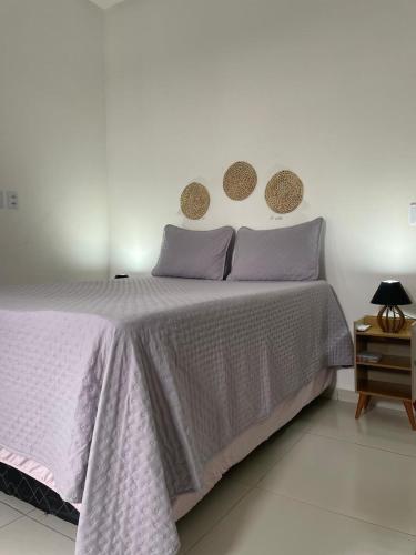 a bedroom with a large bed with purple pillows at Viver de Temporada Canindé- 10 Minutos de Piranhas- 3 Minutos do Centro garagem para 3 carros in Canindé de São Francisco