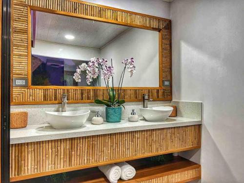 a bathroom with two sinks and a large mirror at Sassy Sloth Villa in Fortuna