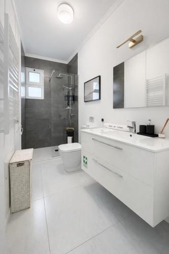 a white bathroom with a sink and a toilet at RETIRO Da CALHETA in Estreito da Calheta