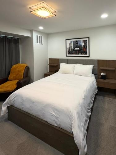a bedroom with a large white bed and a chair at Modern Luxury Home I Sleeps 8 I 10min to Downtown in Denver