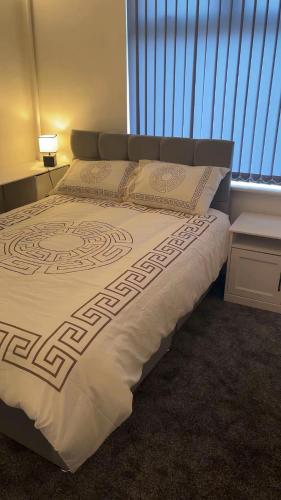 a large bed in a bedroom with a window at PLUS Properties Moston in Stoke on Trent