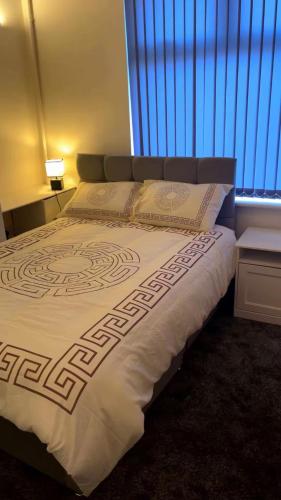 a large bed in a room with a window at PLUS Properties Moston in Stoke on Trent