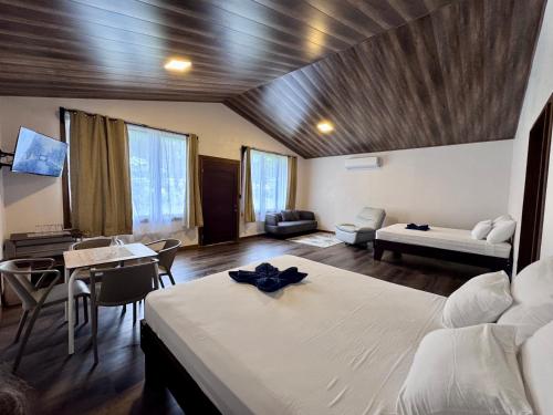 a bedroom with a bed and a living room at Termales del Arenal in Fortuna