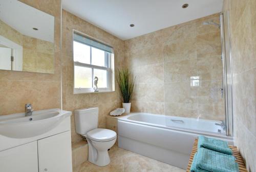 a bathroom with a tub and a toilet and a sink at 5 Bed in Amroth oc-pw9067 in Amroth
