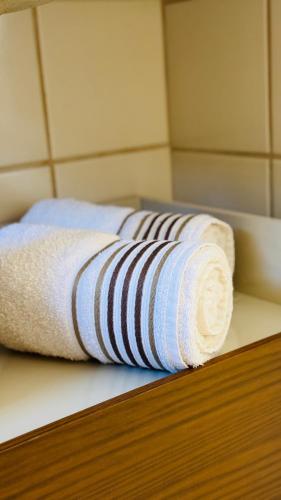 two rolled towels on a shelf in a room at Apê com vista para o mar e clima animado in Vitória
