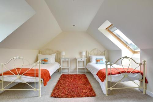two beds in a attic bedroom with a window at 5 Bed in Amroth oc-pw9067 in Amroth