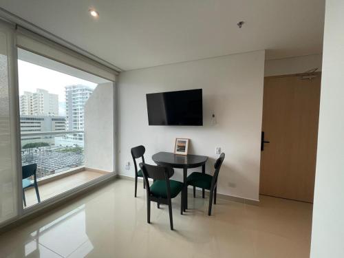 a dining room with a table and chairs and a large window at Edificio Eira in Santa Marta